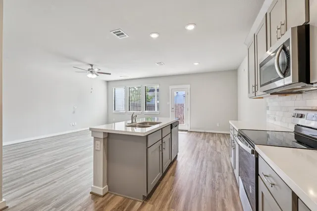 a kitchen with a sink a refrigerator a microwave and cabinets