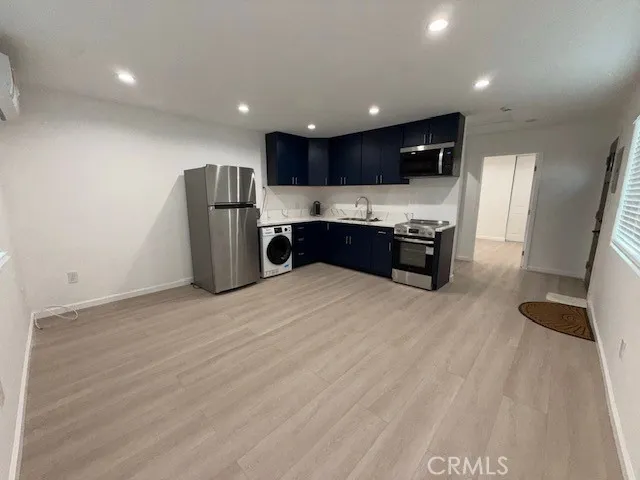 a kitchen with stainless steel appliances kitchen island granite countertop a refrigerator and a stove top oven