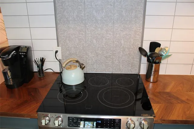 a living room with a stove and a refrigerator