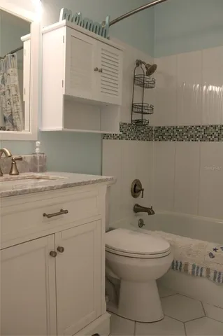 a bathroom with a granite countertop sink a toilet and shower