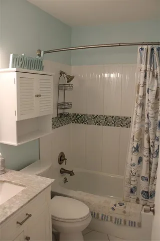 a bathroom with a granite countertop sink toilet and mirror