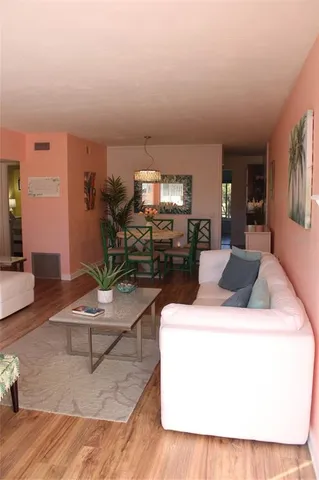 a dining room with furniture potted plants and wooden floor