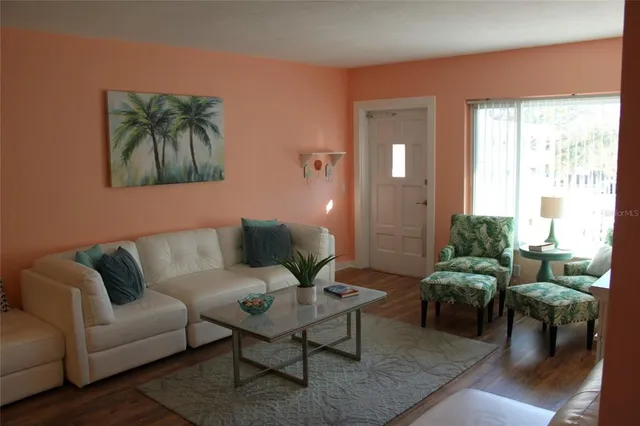 a living room with furniture a flat screen tv and a large window