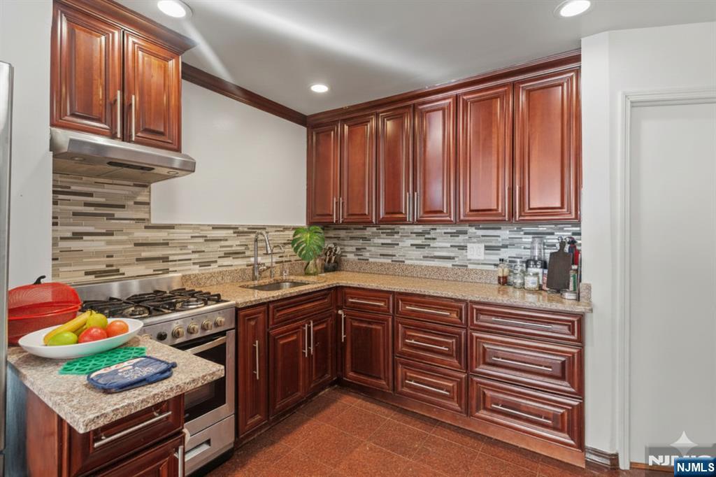 436 Undercliff Avenue, Unit 1 Edgewater, NJ 07020 - Photo 3 of 16 a kitchen with stainless steel appliances granite countertop a sink and cabinets