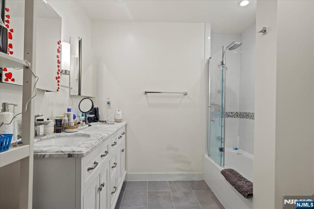 436 Undercliff Avenue, Unit 1 Edgewater, NJ 07020 - Photo 6 of 16 a bathroom with a granite countertop sink a toilet and shower