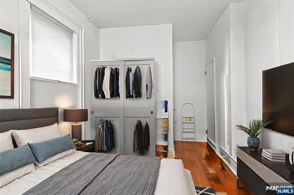 436 Undercliff Avenue, Unit 1 Edgewater, NJ 07020 - Photo 7 of 16 a bedroom with a bed and flat screen tv