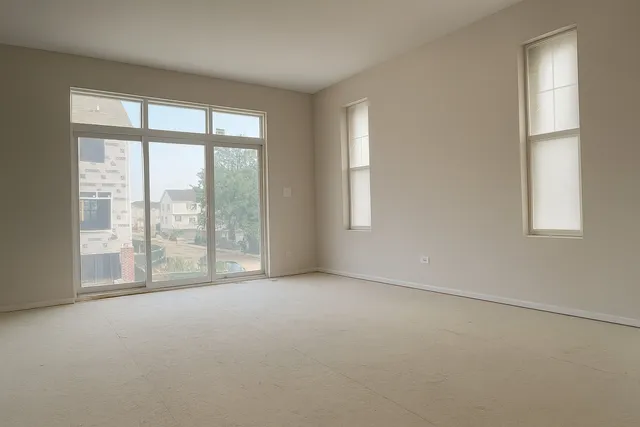 an empty room with windows and city view