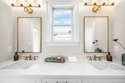 a large bed sitting in a bedroom next to a window and potted plant