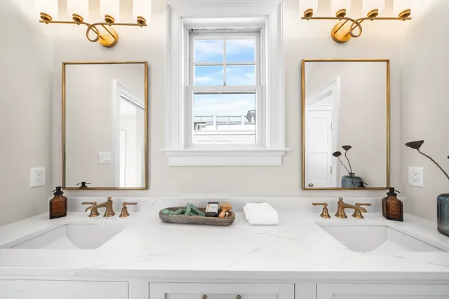 a large bed sitting in a bedroom next to a window and potted plant