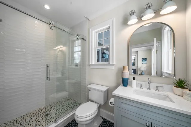 a bathroom with a sink toilet vanity and shower