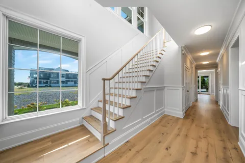 a living room with furniture kitchen view and a large window