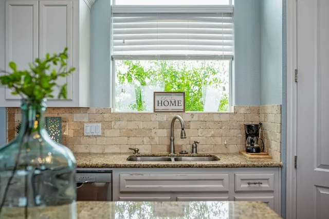 a kitchen with granite countertop white cabinets and stainless steel appliances