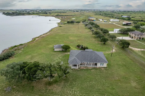 a view of a lake with a yard and large trees