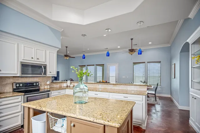 a kitchen with granite countertop a sink and refrigerator