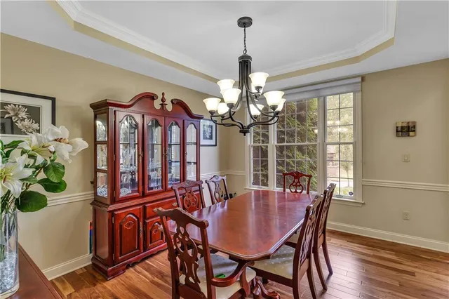 a view of a dining room with furniture a chandelier and wooden floor