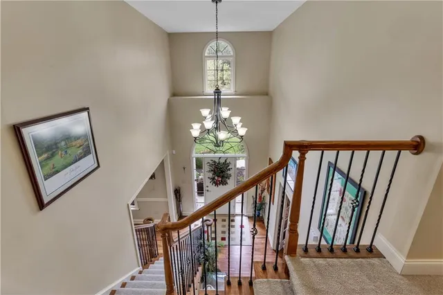 a view of a hallway with windows chandelier and stairs