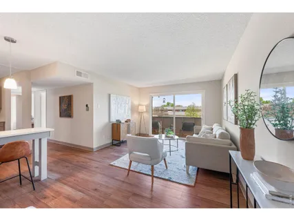a living room with furniture a large window and kitchen view