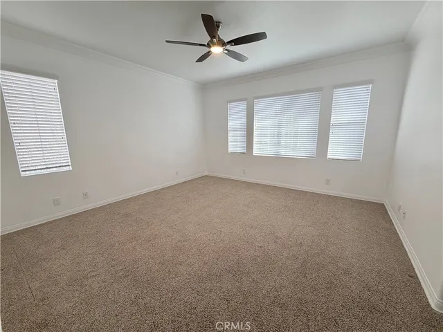 an empty room with a window and a ceiling fan