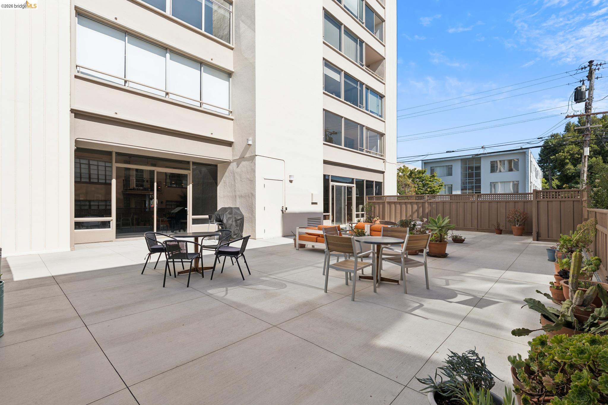 2550 Dana Street, Unit 2F Berkeley, CA 94704 - Photo 18 of 32 a view of a patio with table and chairs and wooden fence