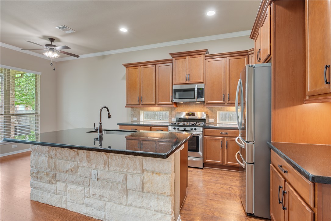 3085 Archer Circle Bryan, TX 77808 - Photo 7 of 31 a kitchen with kitchen island granite countertop a sink appliances cabinets and furniture