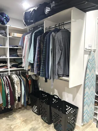 a view of walk in closet with clothes and shoes