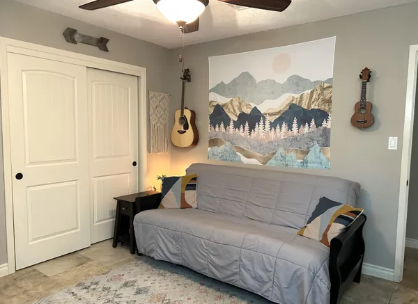 a bedroom with a bed and painting on the wall
