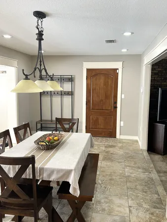 a view of a dining room with furniture and chandelier