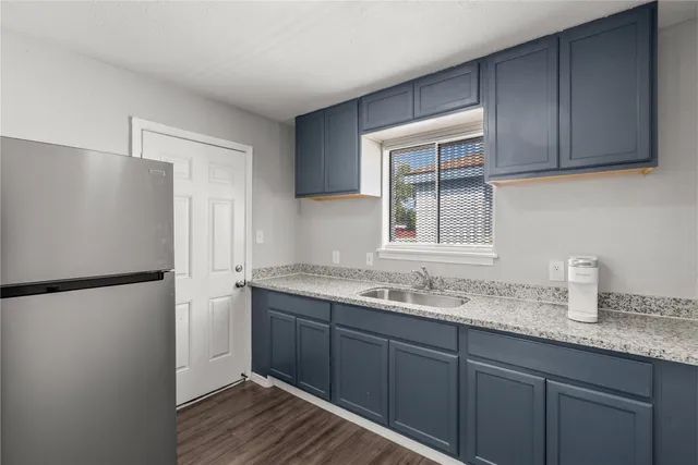 a kitchen with a sink a refrigerator and cabinets