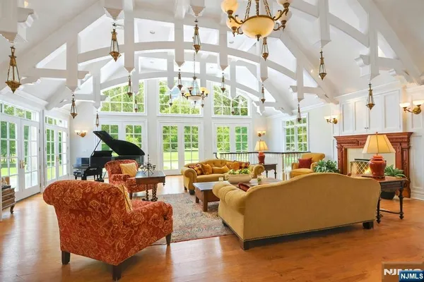 a living room with furniture a chandelier and a large window