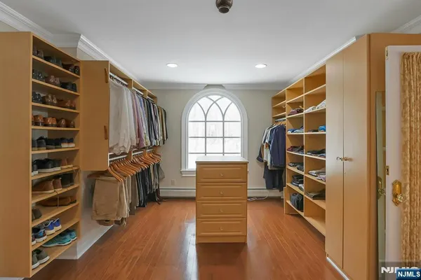 a view of walk in closet with clothes and shoes