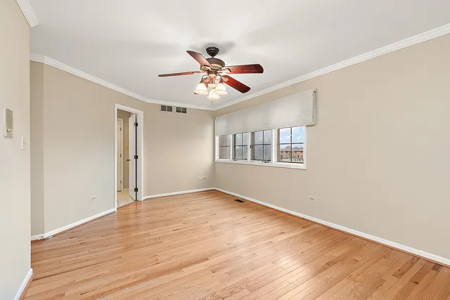 a view of an empty room with window and wooden floor