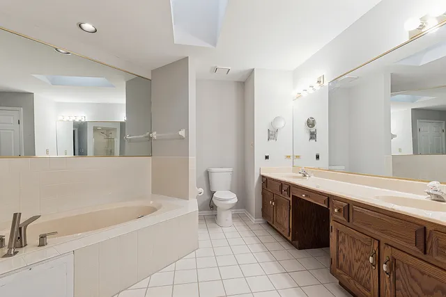 a bathroom with a granite countertop bathtub sink double and mirror