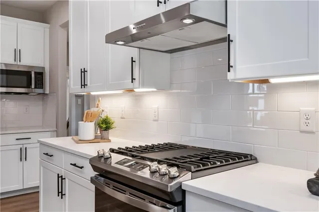 a stove top oven sitting inside of a kitchen