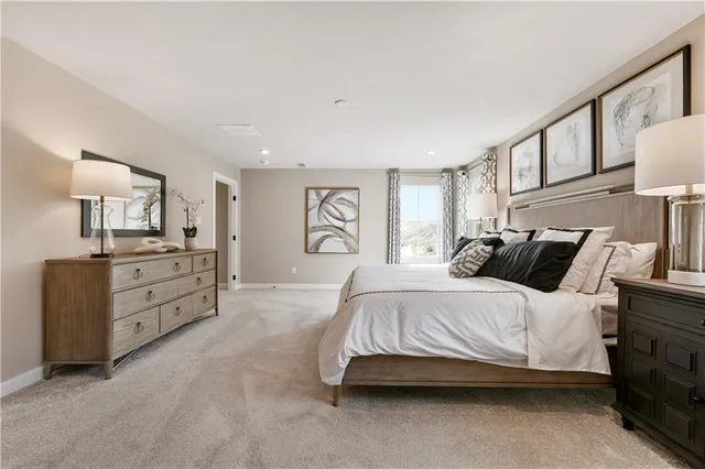 a spacious bedroom with a bed and a cabinets