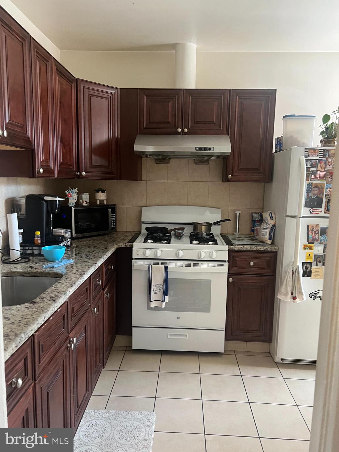 1236 Sanger Street Philadelphia, PA 19124 - Photo 6 of 7 a kitchen with stainless steel appliances granite countertop a stove a sink and a refrigerator