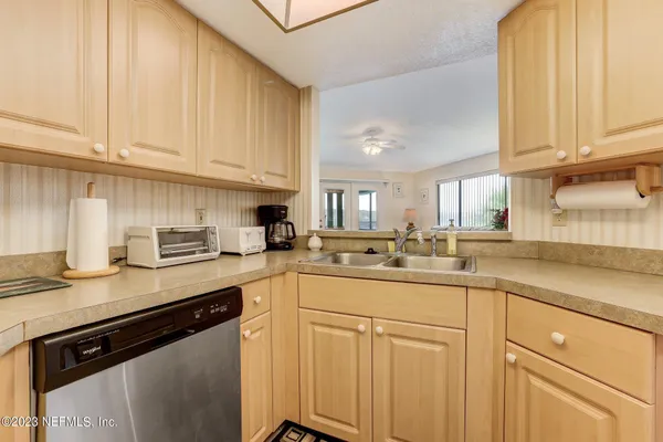 a kitchen with stainless steel appliances granite countertop a sink and cabinets with wooden floor