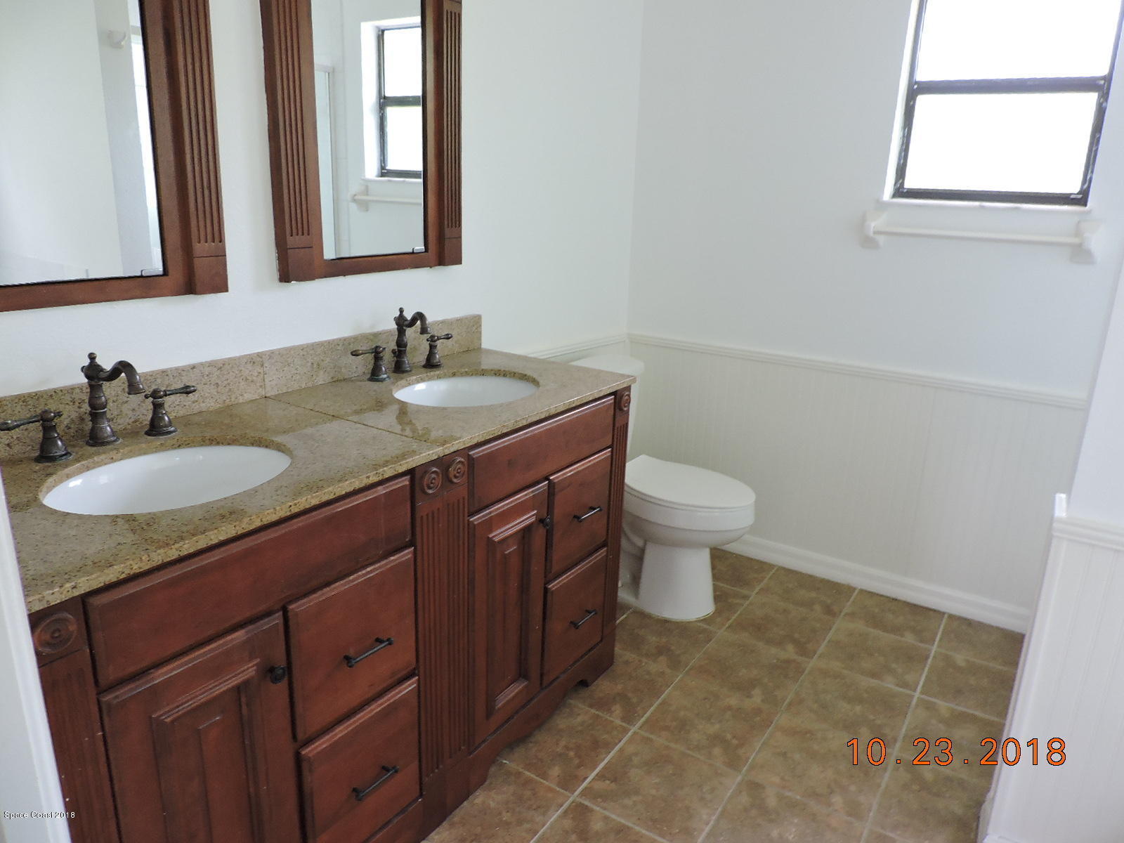 2195 Ladner Road Northeast Palm Bay, FL 32907 - Photo 9 of 14 a bathroom with a granite countertop sink a toilet and a mirror