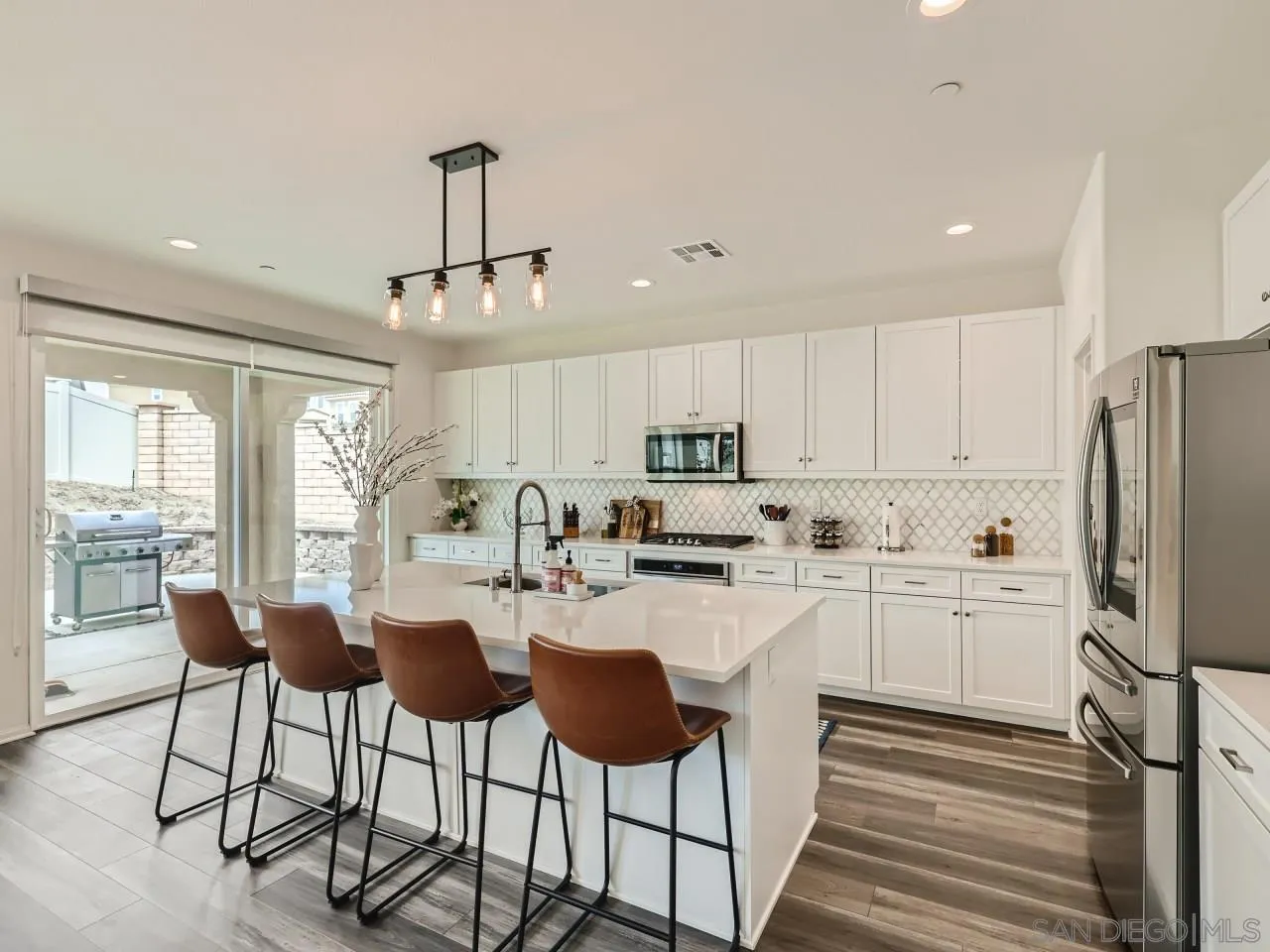 1263 Spivey Road Chula Vista, CA 91913 - Photo 4 of 26 a kitchen with refrigerator cabinets dining table and chairs