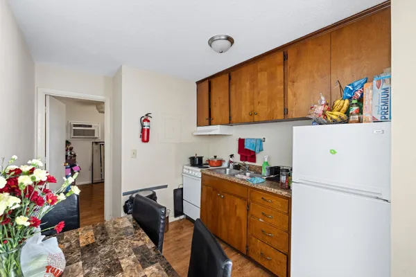 a kitchen with a refrigerator and a stove top oven