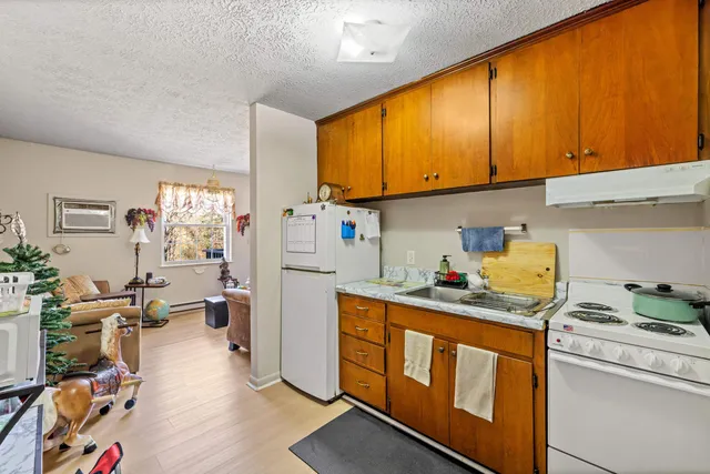 a kitchen with stainless steel appliances granite countertop a sink dishwasher stove refrigerator and cabinets