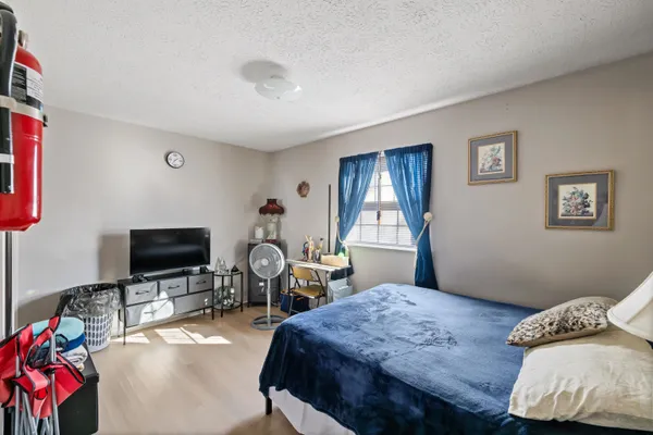 a bedroom with bed a flat tv screen and a closet