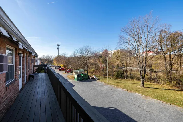 a view of a balcony with wooden floor and trees