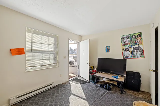 a living room with furniture a flat screen tv and a window