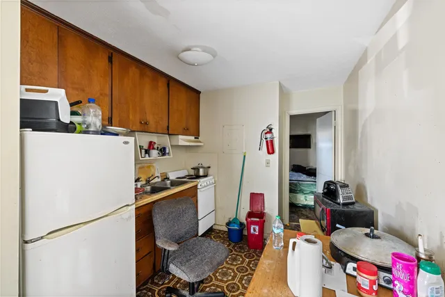 a room with furniture a flat screen tv and a refrigerator