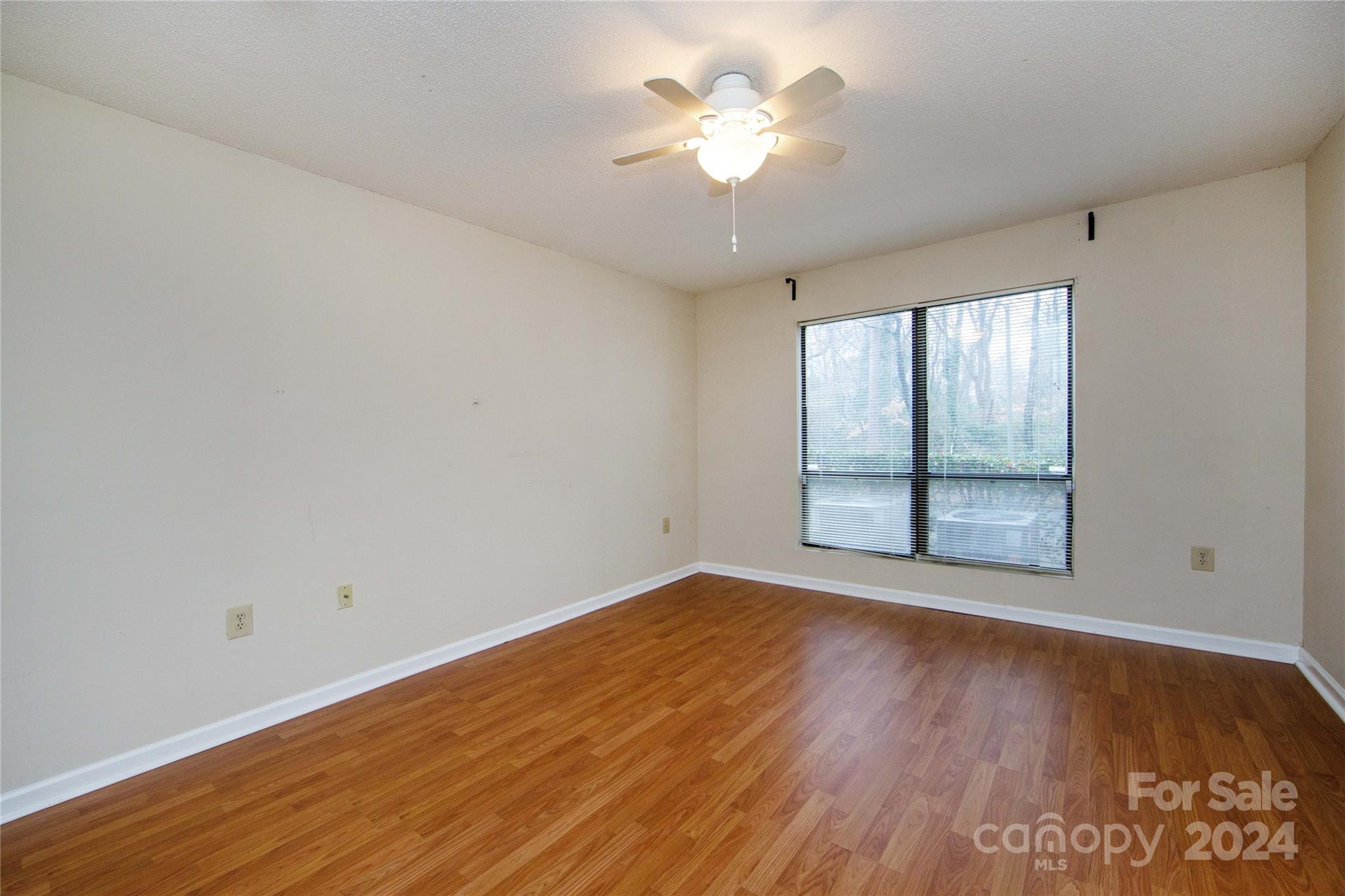 5020 Sardis Road, Unit E Charlotte, NC 28270 - Photo 16 of 27 an empty room with wooden floor and windows