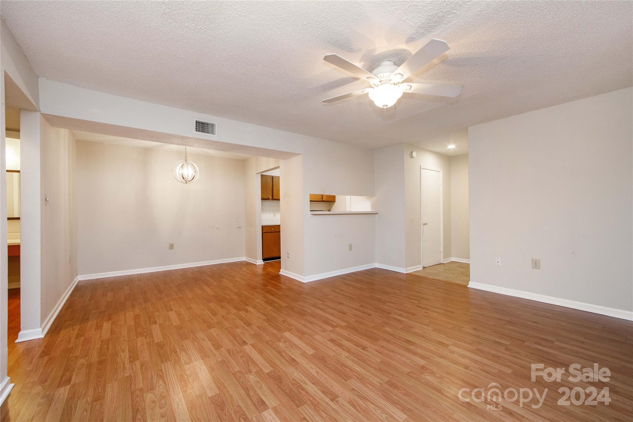 5020 Sardis Road, Unit E Charlotte, NC 28270 - Photo 6 of 27 a view of empty room with wooden floor and ceiling fan