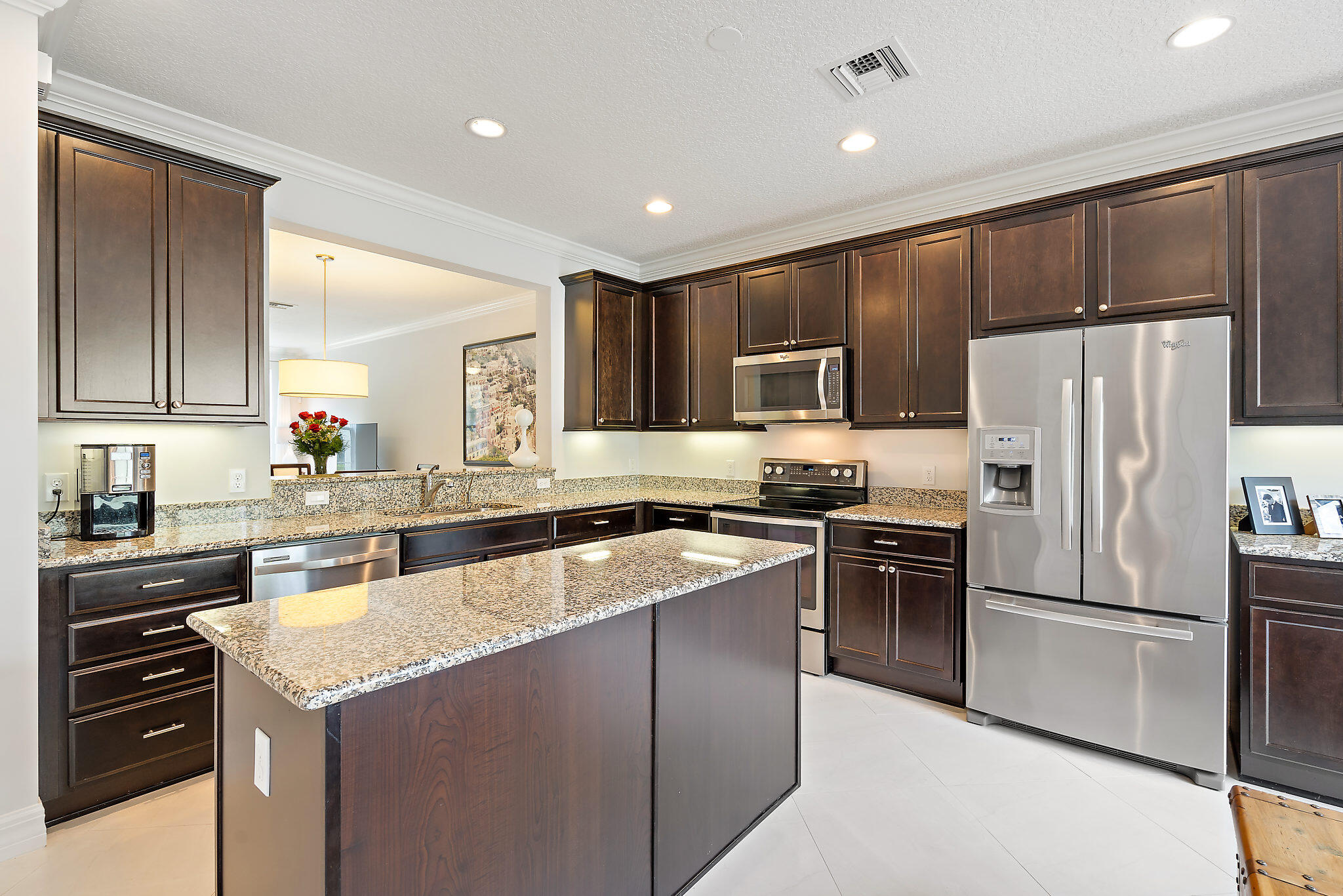 1237 Dakota Drive Jupiter, FL 33458 - Photo 12 of 32 a kitchen with kitchen island granite countertop stainless steel appliances and refrigerator