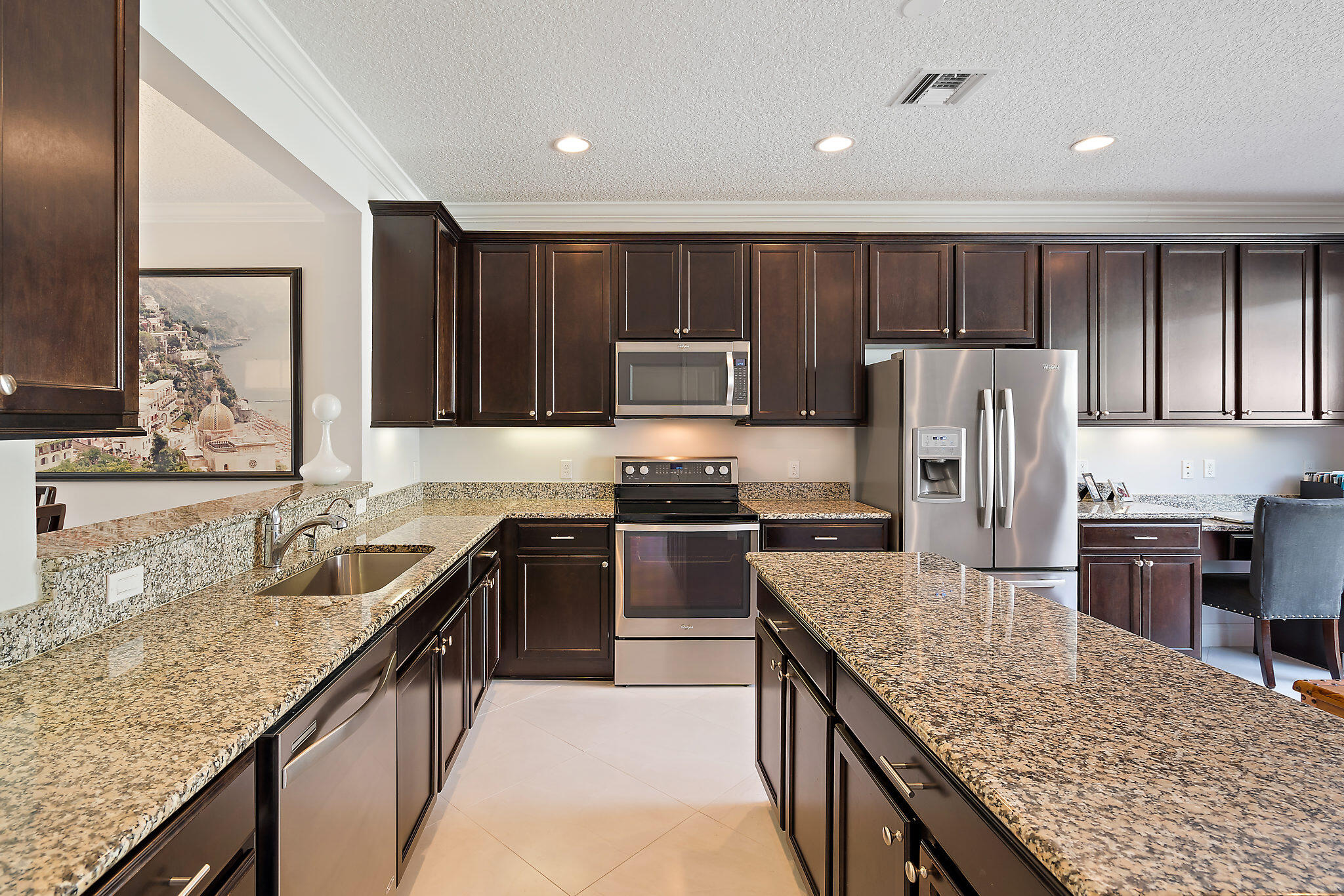 1237 Dakota Drive Jupiter, FL 33458 - Photo 13 of 32 a kitchen with kitchen island granite countertop stainless steel appliances and wooden cabinets