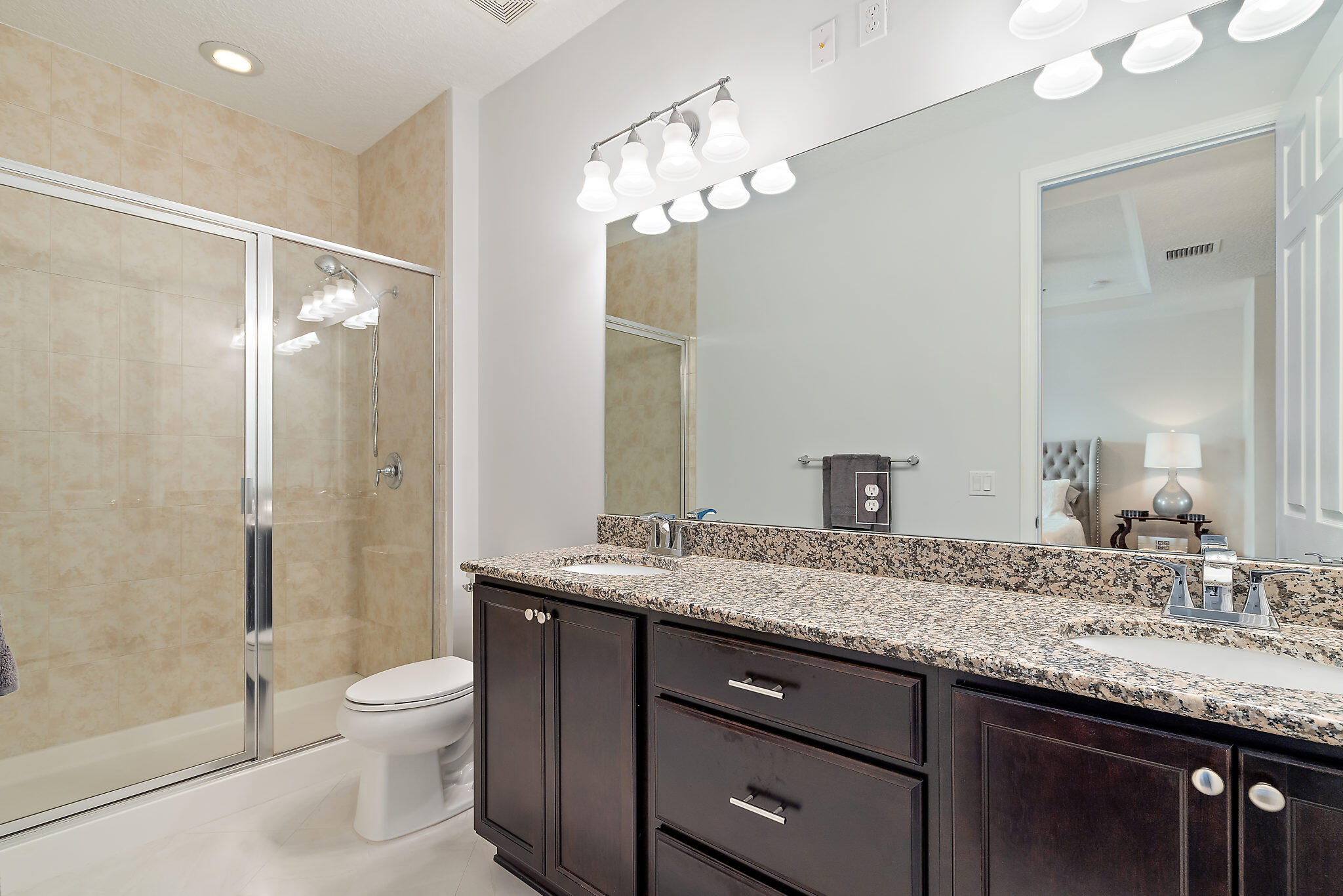 1237 Dakota Drive Jupiter, FL 33458 - Photo 21 of 32 a bathroom with a granite countertop sink a toilet a large mirror a shower and a mirror
