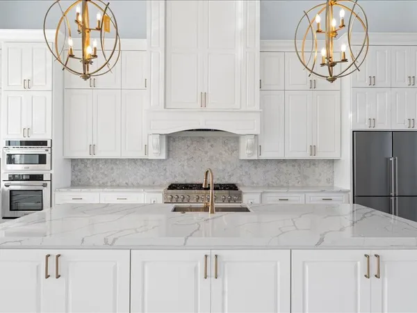 a kitchen with granite countertop a white stove top oven and cabinets